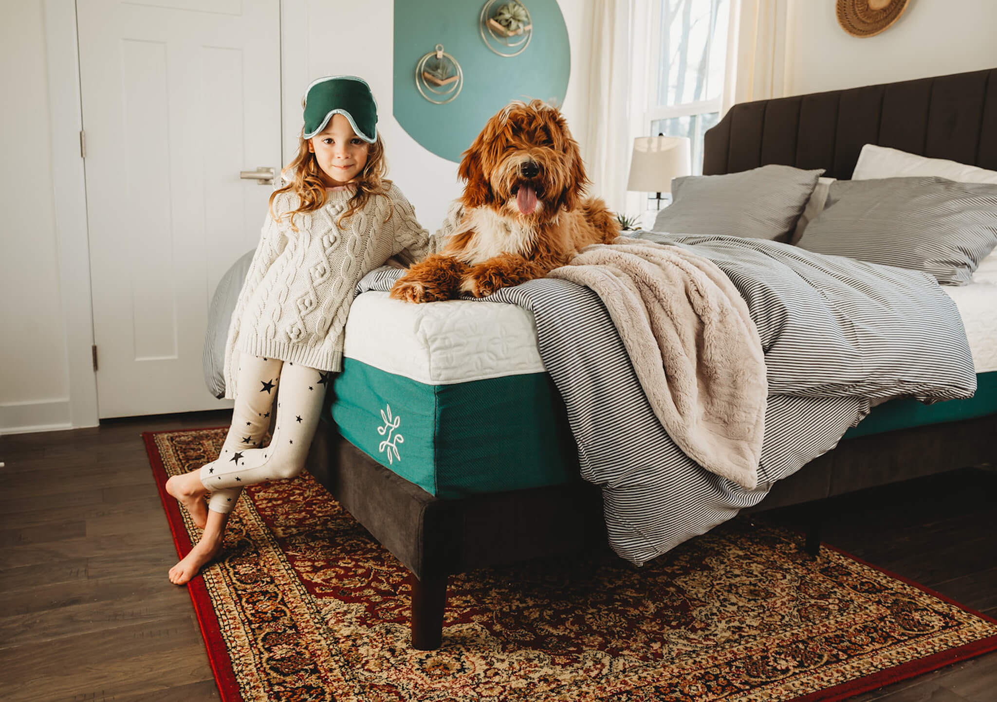 girl and her dog on dark grey bed frame